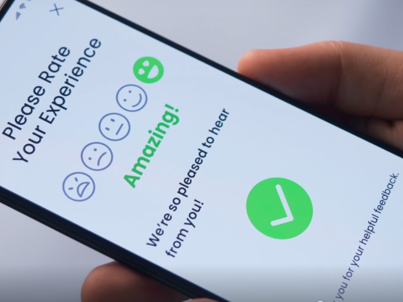 Satisfied customer writing a positive review on a mobile phone