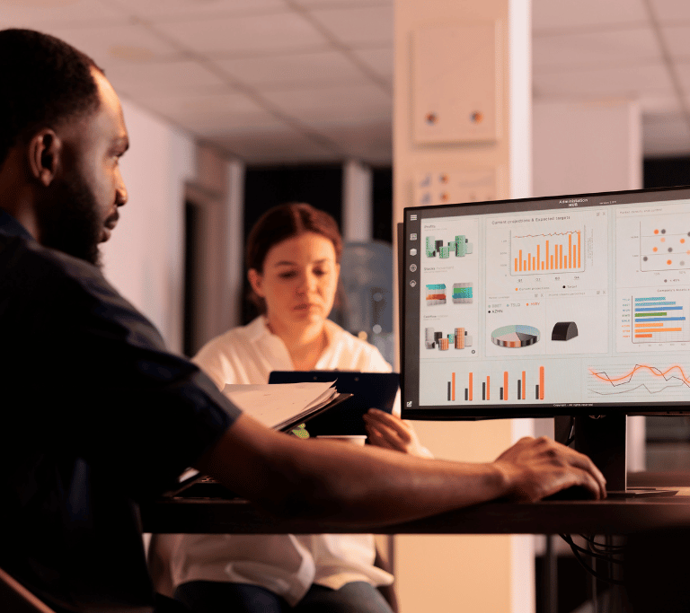 man looking at a computer screen with graphs and charts