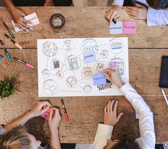 top down view of a conference table with multiple people working on a document