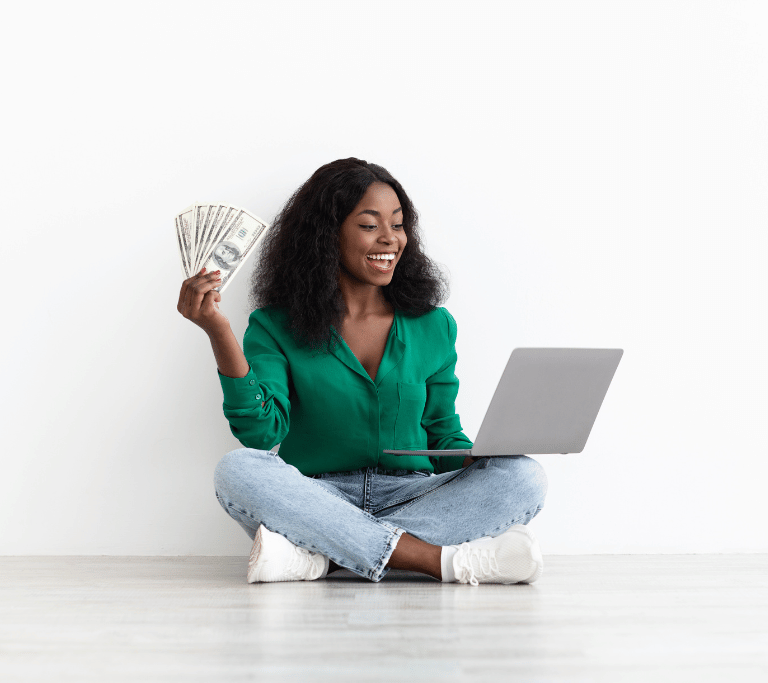 woman holding money and looking at her website
